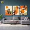 Three piece boho wall art featuring black Modern Calm Plant Leaves with orange sun and green arches on a beige background.